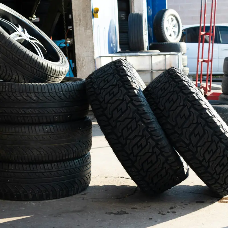 Stack of used car tyres outside a tyre garage